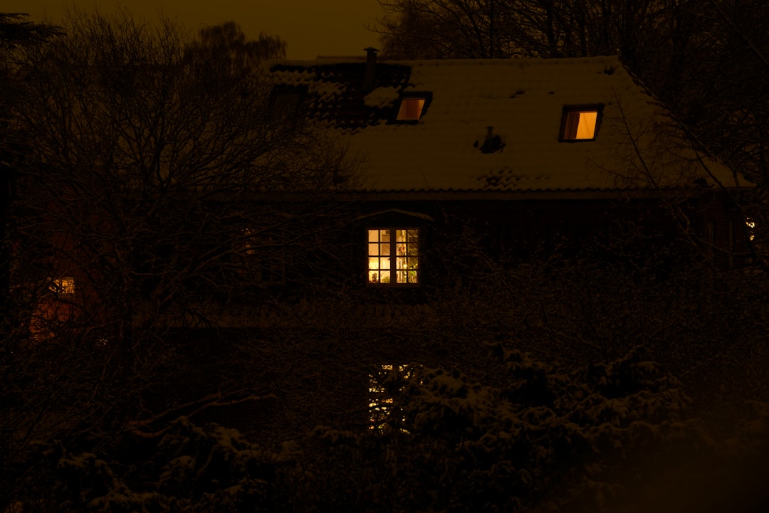 Warm cozy home with illuminated windows on a cold winter evening perfect for relaxing with cannabis