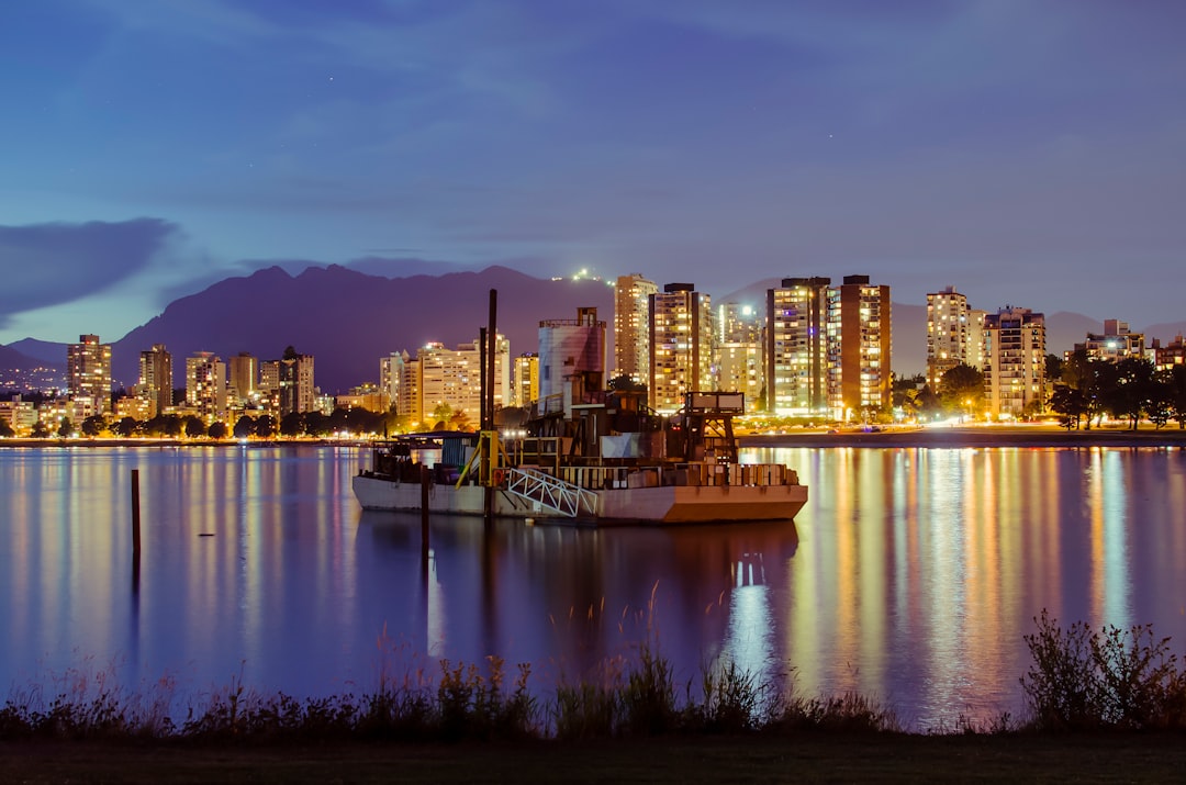 Vancouver city skyline reflected in calm water at night with glowing lights