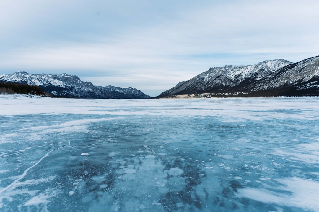Frozen lake surrounded by snow-covered mountains in a northern Canadian winter landscape