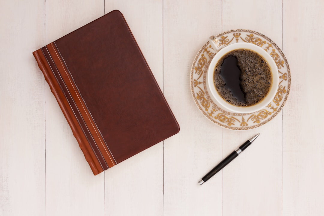Cup of coffee next to a notebook and pen for journaling and preparation