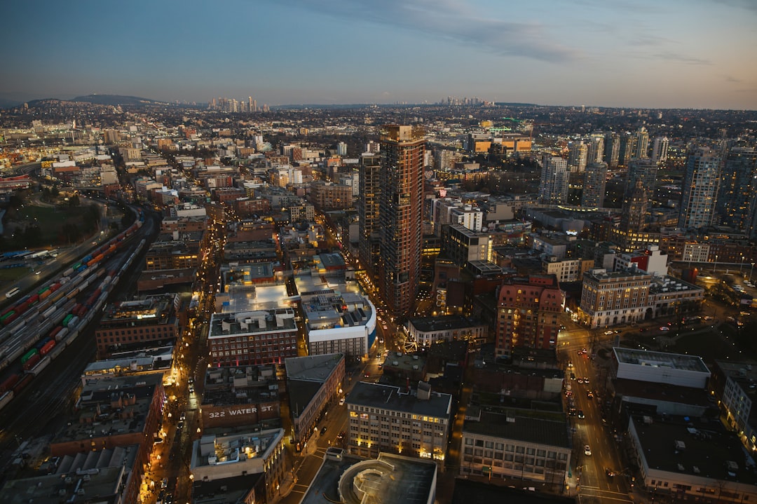 Aerial view of downtown Vancouver skyline at dusk with mountains in background