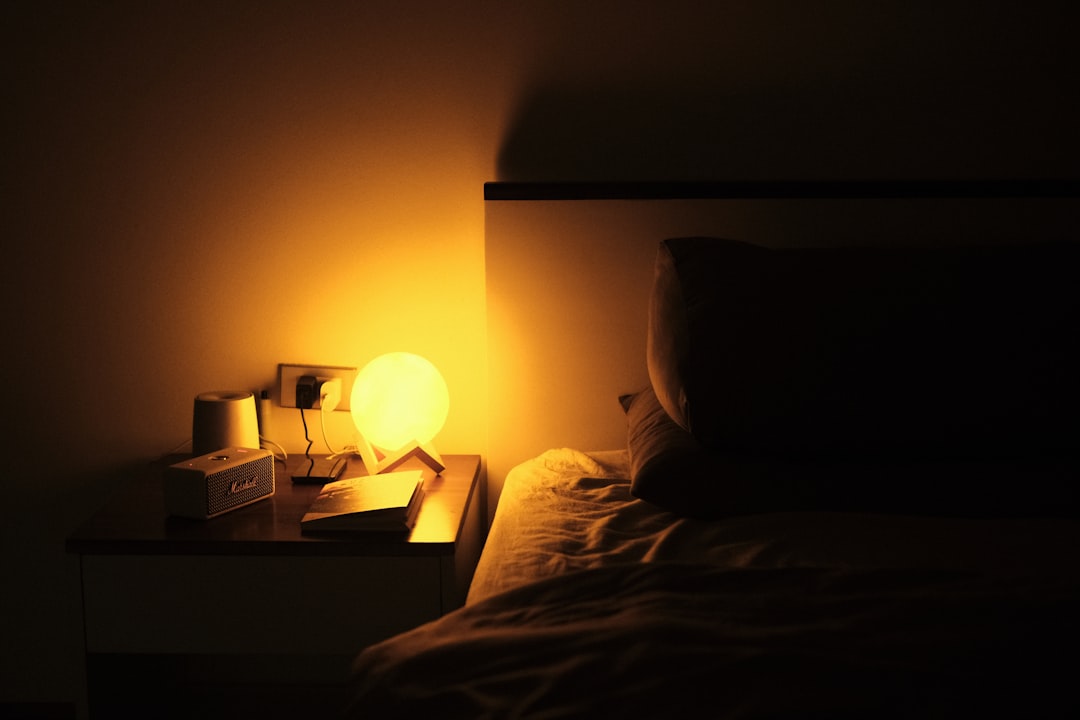 Cozy bedroom nightstand with lamp representing restful sleep supported by CBD gummies