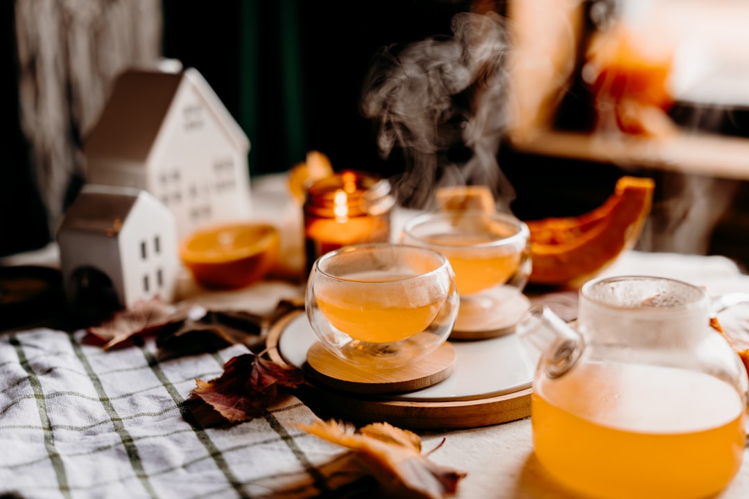 Steaming hot tea in clear glasses surrounded by warm autumn decor for a relaxing evening
